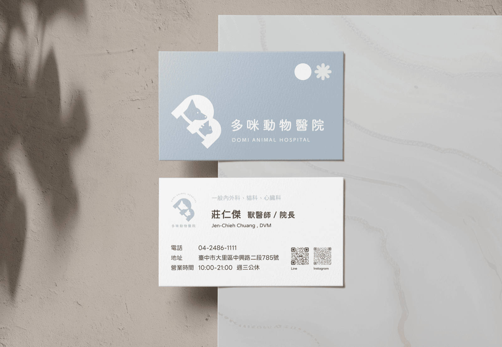 多咪動物醫院名片正反面設計,正面為淺藍底白色貓狗剪影標誌與院名,背面為院長姓名職稱、聯絡資訊與 LINE、Instagram 兩組 QR Code